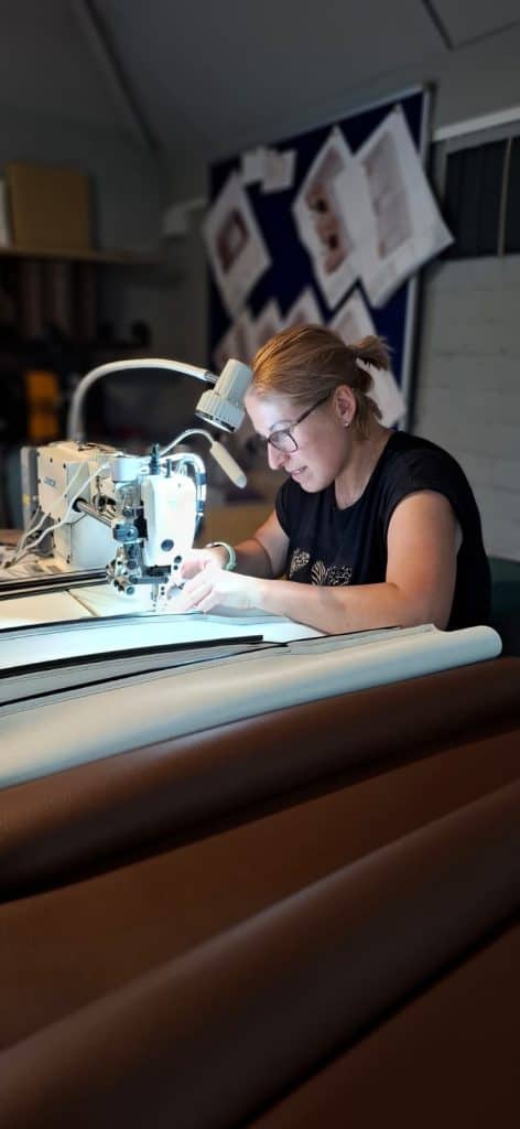 I&M Upholstery craftsman sewing upholstery in the workshop in Surrey